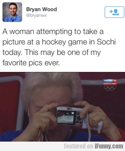 A Woman Attempting To Take A Picture At A Hockey..