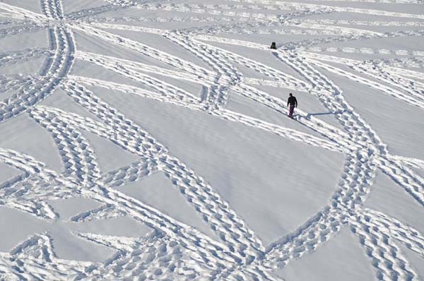 Simon walks over layers of fresh snow in special shoes to create his mind-boggling art.